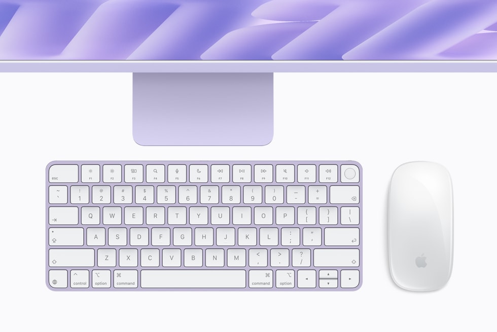 Pandangan atas pada latar kelabu cerah: di bahagian atas, separuh bawah sebuah iMac ungu, skrinnya memaparkan garisan abstrak ungu di atas dagu dan tapak ungu; di bawahnya, sebuah Magic Keyboard berbingkai ungu dengan kekunci putih, baris fungsi F1–F12 dan satu kekunci Touch ID bulat di kanan atas, bersebelahan sebuah Magic Mouse putih dengan logo Apple kelabu. Teks: tulisan pada kekunci papan kekunci, seperti esc, F1–F12, kekunci huruf dan nombor, control, option dan command.
