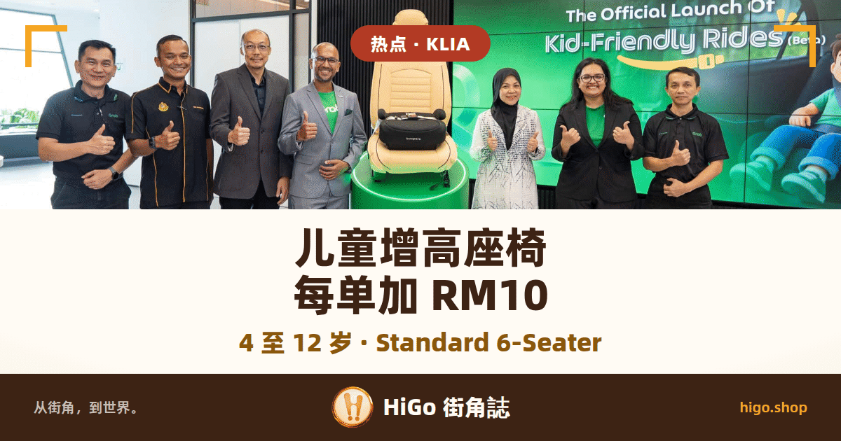 发布会合影：七个人在室内并排站着比大拇指，中间一个绿色圆柱台上放着一张米色汽车座椅，椅面上是一块黑色增高坐垫，身后右侧一整面绿色屏幕写着 The Official Launch Of Kid-Friendly Rides (Beta)，左半边是深色室内墙面与玻璃隔断；文字：热点 · KLIA；儿童增高座椅 每单加 RM10；4 至 12 岁 · Standard 6-Seater