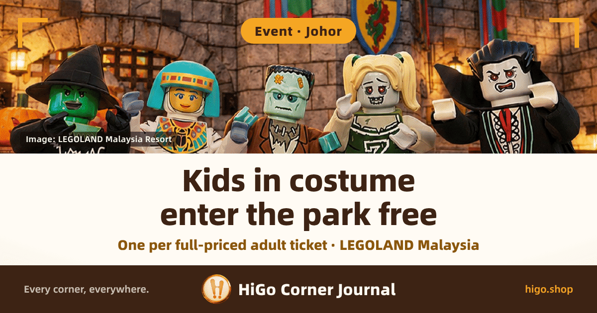 The top half is an official LEGOLAND Malaysia Resort photograph: five life-size LEGO Halloween characters standing in front of a castle wall, from left to right a green-faced witch in a black pointed hat, a Mummy Queen wrapped in white bandages with a turquoise headdress and a colourful gold-trimmed collar, a green-faced Frankenstein with a patch on his forehead in a brown jacket, a zombie cheerleader with blonde pigtails and a large letter Z on her green-and-white kit, and Lord Vampyre in a black suit with a red-lined high-collared cape; behind them are stone castle walls, a shield banner with a red flower crest and red-and-green striped banners, a wall lantern on the left and a pumpkin at the left edge of the frame. A gold right-angle bracket sits in each top corner and a dark credit card in the lower left of the photo. The lower half is a warm white text band, with a dark brown brand strip at the very bottom. Text: a rounded tag at the top reads “Event · Johor”, the credit card reads “Image: LEGOLAND Malaysia Resort”, the headline runs over two lines, “Kids in costume” and “enter the park free”, a gold-brown line below reads “One per full-priced adult ticket · LEGOLAND Malaysia”, and the bottom strip reads “Every corner, everywhere.”, “HiGo Corner Journal” and “higo.shop”.